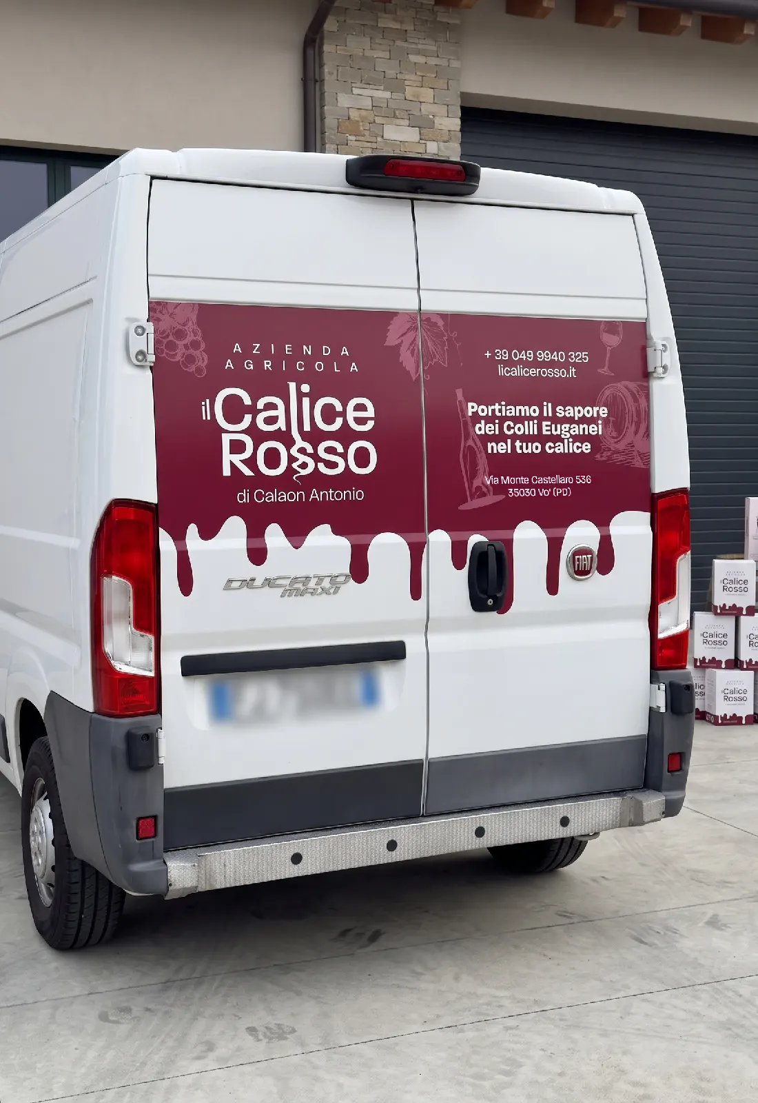 Il furgone aziendale Il Calice Rosso personalizzato con la grafica a colatura di vino sul portellone posteriore